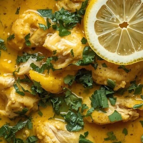 Golden turmeric chicken soup with herbs and lemon slices